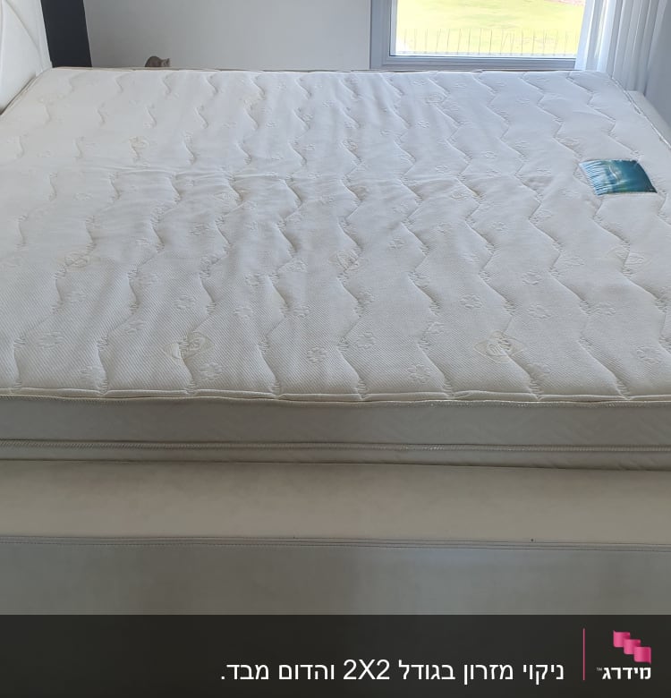 מזרן לבן על מיטה בחדר מואר